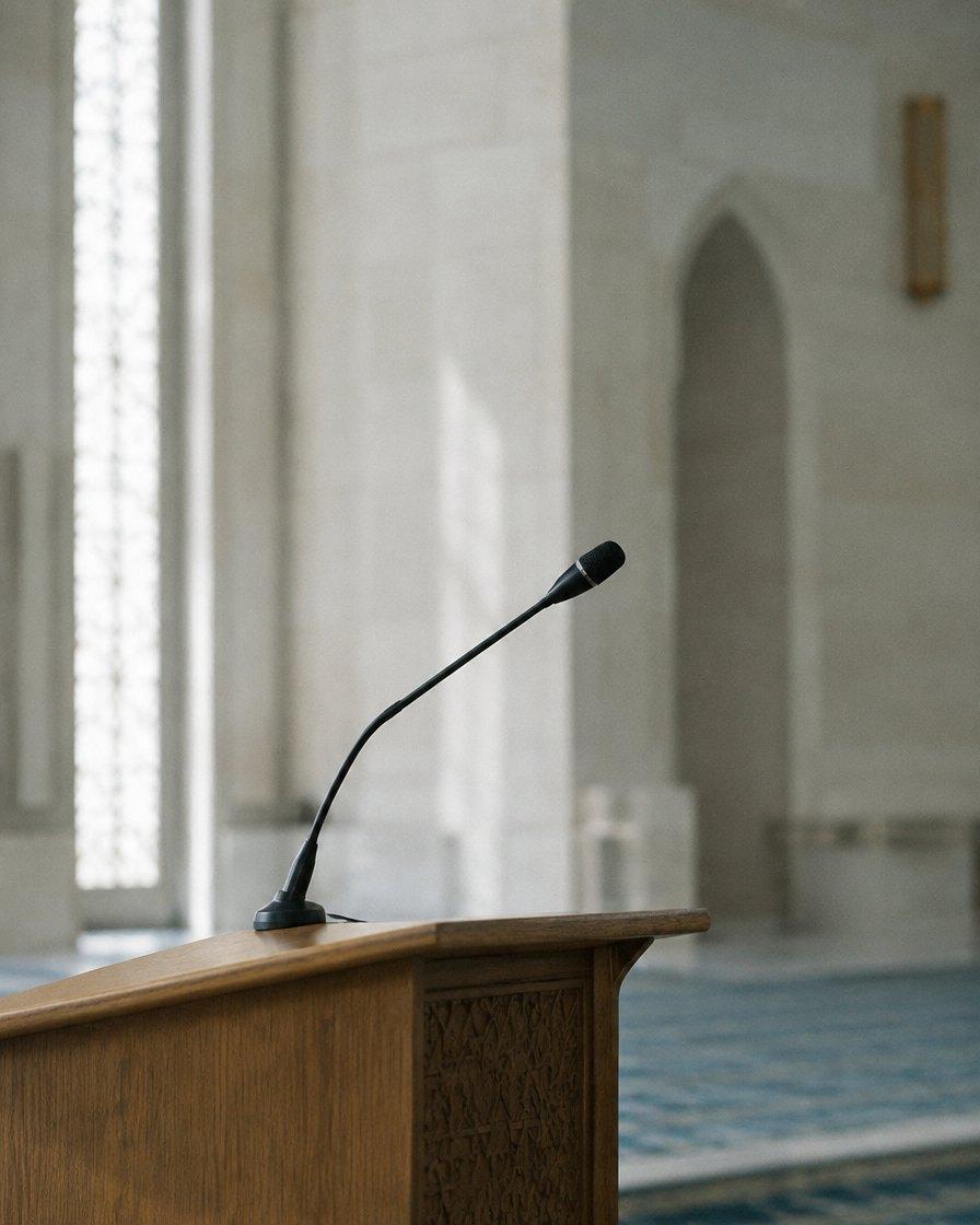 Slim microphone on a wooden lectern in a mosque
